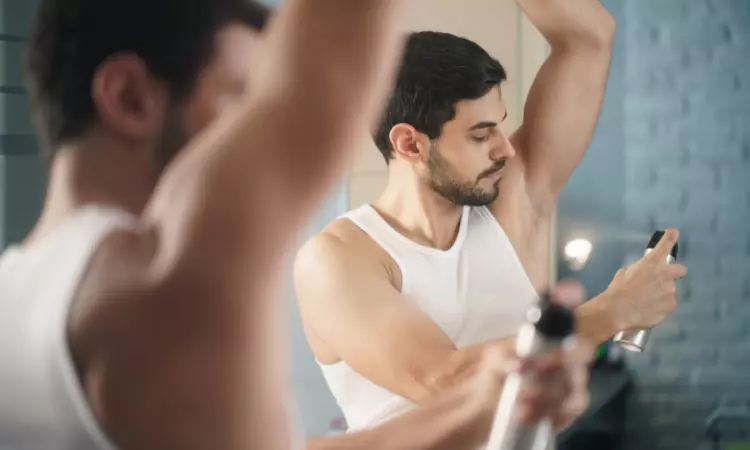 a man spraying deodorant under arms